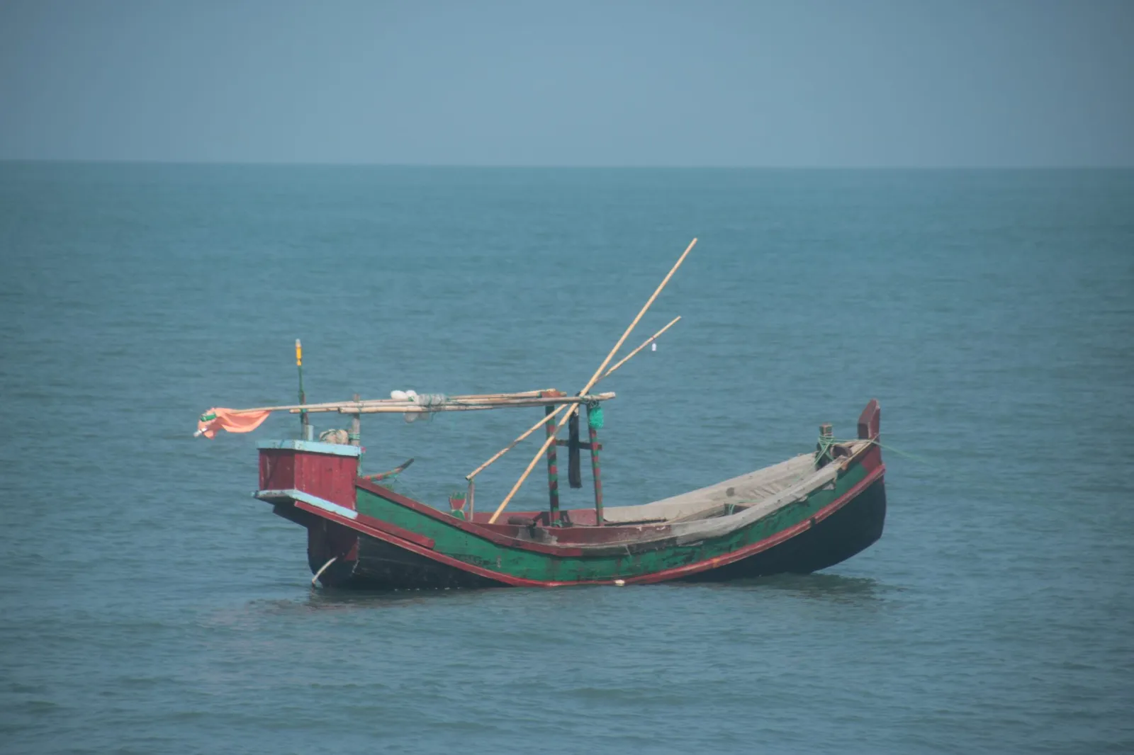 A traditional wooden fishing boat at anchor on open water